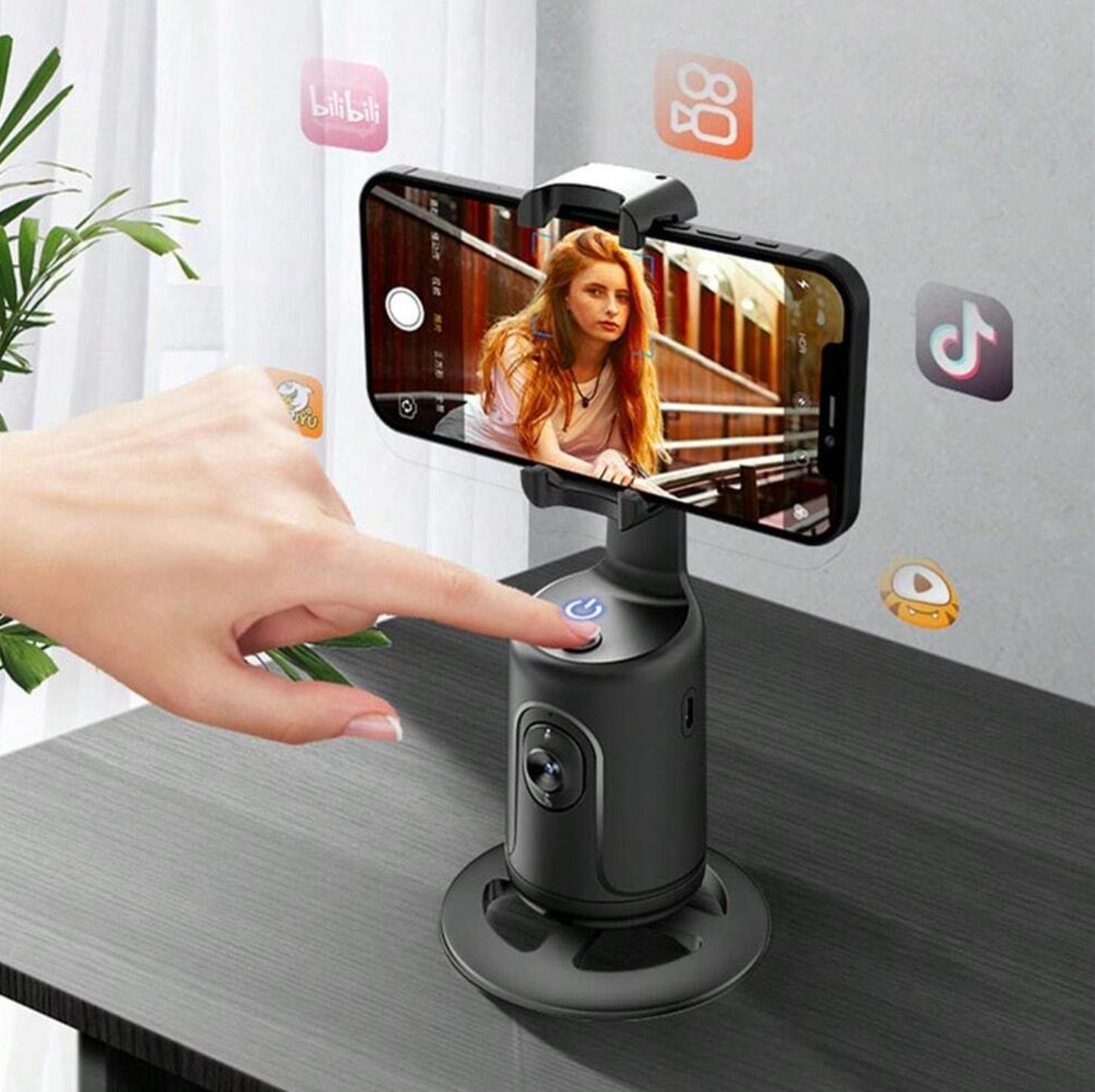 Smartphone holder with a phone displaying a video on a table, with a hand interacting with it.